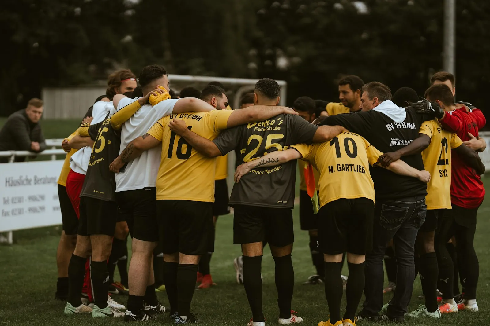 Equipo amateur abrazado en círculo antes de un partido